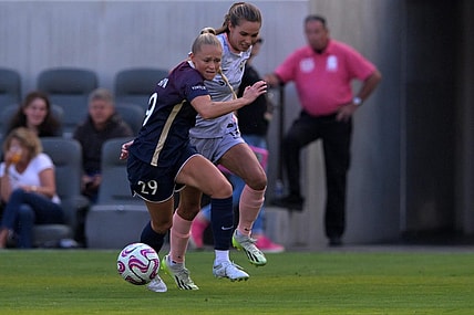 Jul 9, 2023; Los Angeles, California, USA; Angel City FC midfielder Dani Weatherholt (17) and North Carolina Courage forward Millie Farrow (29) battle for the ball during the first half at BMO Stadium. Mandatory Credit: Jayne Kamin-Oncea-USA TODAY Sports