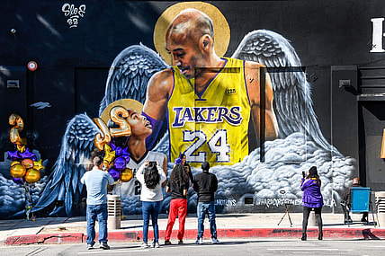 Jan 26, 2021; Los Angeles, California, USA; Fans gather at a mural of Kobe Bryant and his daughter Gianna painted on the wall of Hardcore Fitness Bootcamp gym in downtown Los Angeles. Bryant and his daughter and seven other persons died in a helicopter crash in Calabasas, Calif. on Jan. 26, 2020. Mandatory Credit: Robert Hanashiro-USA TODAY Sports