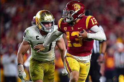 Nov 26, 2022; Los Angeles, California, USA; Southern California Trojans quarterback Caleb Williams (13) runs the ball ahead of Notre Dame Fighting Irish linebacker JD Bertrand (27)  during the second half at the Los Angeles Memorial Coliseum. Mandatory Credit: Gary A. Vasquez-USA TODAY Sports