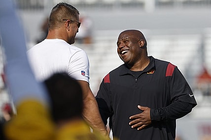 Jul 28, 2023; Ashburn, VA, USA; Washington Commanders assistant head coach/offensive coordinator Eric Bieniemy (R) jokes with Commanders defensive line coach Jeff Zgonina (L) during warmup on day three of Commanders training camp at OrthoVirginia Training Center. Mandatory Credit: Geoff Burke-USA TODAY Sports