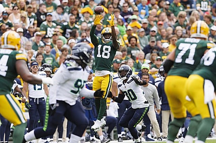 Aug 26, 2023; Green Bay, Wisconsin, USA;  Green Bay Packers wide receiver Malik Heath (18) leaps to catch a pass in front of Seattle Seahawks cornerback Michael Jackson (30) during the first quarter at Lambeau Field. Mandatory Credit: Jeff Hanisch-USA TODAY Sports