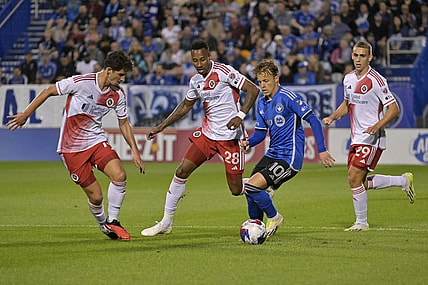 Aug 26, 2023; Montreal, Quebec, CAN; CF Montreal midfielder Bryce Duke (10) dribbles the ball around New England Revolution midfielder Mark-Anthony Kaye (28) and midfielder Ian Harkes (14) during the first half at Stade Saputo. Mandatory Credit: Eric Bolte-USA TODAY Sports