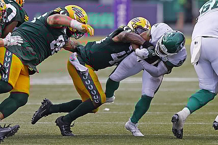 Jun 11, 2023; Edmonton, Alberta, CAN; Saskatchewan Roughriders running back Frankie Hickson (20) is tackled by Edmonton Elks linebacker Myles Morgan (45) during the second half at Commonwealth Stadium. Mandatory Credit: Perry Nelson-USA TODAY Sports