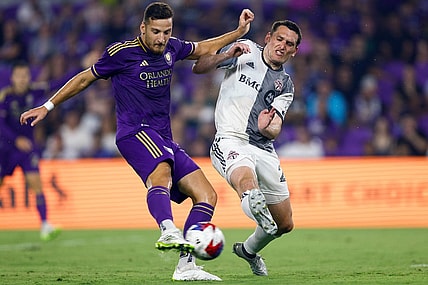 Jul 4, 2023; Orlando, Florida, USA; Orlando City forward Ercan Kara (9) shoots and scores as Toronto FC defender Shane O'Neill (27) defends during the second half at Exploria Stadium. Mandatory Credit: Douglas DeFelice-USA TODAY Sports