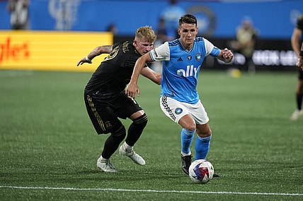 Aug 26, 2023; Charlotte, North Carolina, USA; Charlotte FC midfielder Ashley Westwood (8) plays the ball pressured by Los Angeles FC midfielder Mateusz Bogusz (19) in the second half in the second half at Bank of America Stadium. Mandatory Credit: Jim Dedmon-USA TODAY Sports