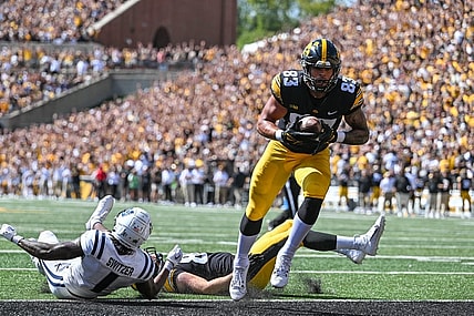 Sep 2, 2023; Iowa City, Iowa, USA; Iowa Hawkeyes tight end Erick All (83) scores on a touchdown pass as Utah State Aggies safety Anthony Switzer (1) and Iowa tight end Steven Stilianos (86) lay on the turf during the first quarter at Kinnick Stadium. Mandatory Credit: Jeffrey Becker-USA TODAY Sports