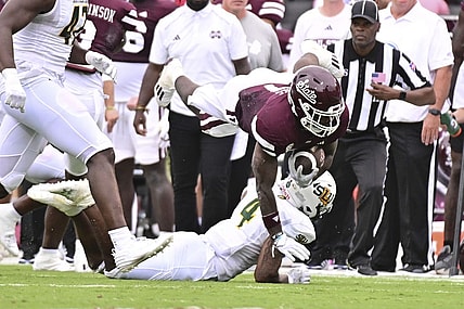 Sep 2, 2023; Starkville, Mississippi, USA; Mississippi State Bulldogs running back Jo'Quavious Marks (7) dives over Southeastern Louisiana Lions defensive back Ian Goodly (4) during the second quarter at Davis Wade Stadium at Scott Field. Mandatory Credit: Matt Bush-USA TODAY Sports