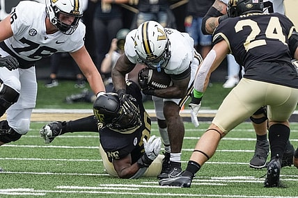 Sep 9, 2023; Winston-Salem, North Carolina, USA; Vanderbilt Commodores running back Patrick Smith (4) is tackled by Wake Forest Demon Deacons defensive lineman Jasheen Davis (30) during the first quarter at Allegacy Federal Credit Union Stadium. Mandatory Credit: Jim Dedmon-USA TODAY Sports