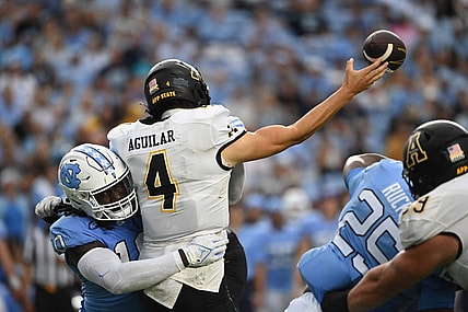 Sep 9, 2023; Chapel Hill, North Carolina, USA; Appalachian State Mountaineers quarterback Joey Aguilar (4) passes the ball as North Carolina Tar Heels defensive lineman Desmond Evans (10) pressures in the second quarter at Kenan Memorial Stadium. Mandatory Credit: Bob Donnan-USA TODAY Sports