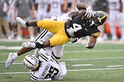 Sep 16, 2023; Iowa City, Iowa, USA; Iowa Hawkeyes running back Leshon Williams (4) runs the ball as Western Michigan Broncos cornerback Aaron Wofford (25) and linebacker Damari Roberson (rear) make the tackle during the first quarter at Kinnick Stadium. Mandatory Credit: Jeffrey Becker-USA TODAY Sports
