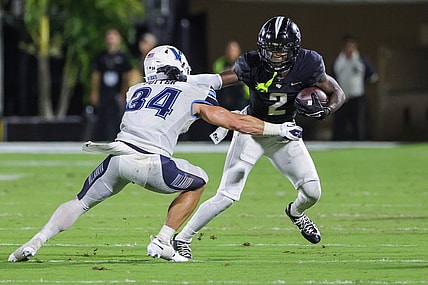 Sep 16, 2023; Orlando, Florida, USA; UCF Knights wide receiver Kobe Hudson (2) runs the ball as Villanova Wildcats defensive back Ethan Potter (34) moves in during the second quarter at FBC Mortgage Stadium. Mandatory Credit: Mike Watters-USA TODAY Sports
