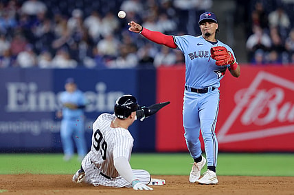 Sep 19, 2023; Bronx, New York, USA; Toronto Blue Jays second baseman Santiago Espinal (5) forces out New York Yankees right fielder Aaron Judge (99) at second and throws to first to complete a game ending double play on a ball hit by Yankees designated hitter Giancarlo Stanton (not pictured) during the ninth inning at Yankee Stadium. Mandatory Credit: Brad Penner-USA TODAY Sports