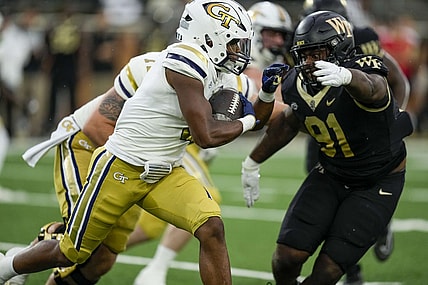 Sep 23, 2023; Winston-Salem, North Carolina, USA;  Georgia Tech Yellow Jackets running back Trey Cooley (0) runs the ball against Wake Forest Demon Deacons defensive lineman Kevin Pointer (91) during the first half at Allegacy Federal Credit Union Stadium. Mandatory Credit: Jim Dedmon-USA TODAY Sports