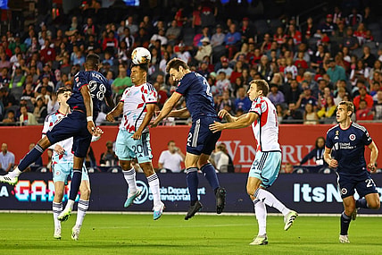 Sep 23, 2023; Chicago, Illinois, USA; Chicago Fire midfielder Jairo Torres (20) heads the ball against New England Revolution defender Dave Romney (2) during the first half at Soldier Field. Mandatory Credit: Mike Dinovo-USA TODAY Sports