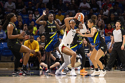 Sep 29, 2023; Arlington, Texas, USA; Las Vegas Aces forward A'ja Wilson (22) looks to move the ball past Dallas Wings forward Natasha Howard (6) and guard Arike Ogunbowale (24) and center Teaira McCowan (7) during the first half during game three of the 2023 WNBA Playoffs at College Park Center. Mandatory Credit: Jerome Miron-USA TODAY Sports