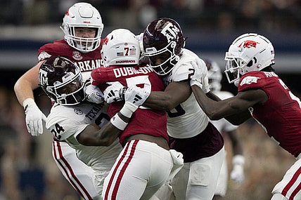 Sep 30, 2023; Arlington, Texas, USA; Arkansas Razorbacks running back Rashod Dubinion (7) is tackled by Texas A&M Aggies linebacker Chris Russell Jr. (24) and defensive back Jacoby Mathews (2) during the first half at AT&T Stadium. Mandatory Credit: Jerome Miron-USA TODAY Sports