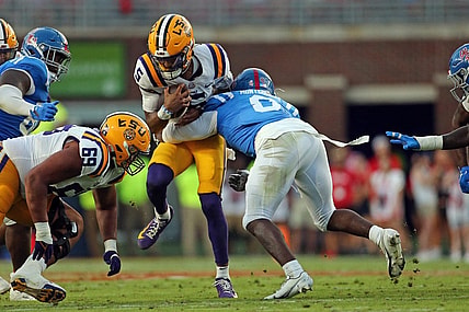 Sep 30, 2023; Oxford, Mississippi, USA; LSU Tigers quarterback Jayden Daniels (5) runs with the ball as Mississippi Rebels linebacker Monty Montgomery (8) makes the tackle during the first half at Vaught-Hemingway Stadium. Mandatory Credit: Petre Thomas-USA TODAY Sports