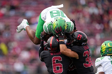 Sep 30, 2023; Stanford, California, USA; Oregon Ducks tight end Kenyon Sadiq (18) attempts to leap over Stanford Cardinal cornerback Collin Wright (6) and safety Mitch Leigber (32) during the second quarter at Stanford Stadium. Mandatory Credit: Darren Yamashita-USA TODAY Sports