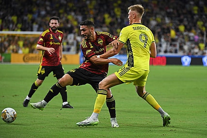 Sep 30, 2023; Nashville, Tennessee, USA; Seattle Sounders FC midfielder Cristian Roldan (7) plays the ball against Nashville SC forward Sam Surridge (9) during the first half at Geodis Park. Mandatory Credit: Christopher Hanewinckel-USA TODAY Sports