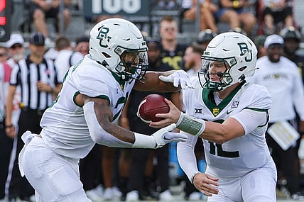 Sep 30, 2023; Orlando, Florida, USA; Baylor Bears quarterback Blake Shapen (12) hands off to running back Dominic Richardson (21) during the first quarter against the UCF Knights at FBC Mortgage Stadium. Mandatory Credit: Mike Watters-USA TODAY Sports