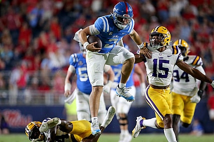 Sep 30, 2023; Oxford, Mississippi, USA; Mississippi Rebels quaterback Jaxson Dart (2) leaps over LSU Tigers defensive back Andre' Sam (14) during the second half at Vaught-Hemingway Stadium. Mandatory Credit: Petre Thomas-USA TODAY Sports