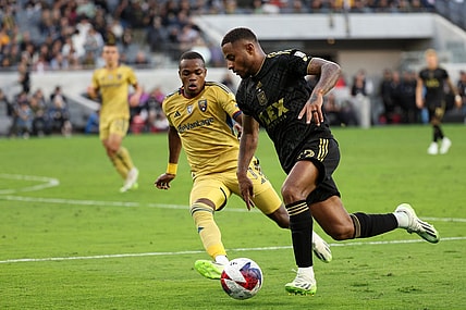 Oct 1, 2023; Los Angeles, California, USA;  Los Angeles FC defender Diego Palacios (12) dribbles the ball against Real Salt Lake forward Carlos Andres Gomez (11) during the first half at BMO Stadium. Mandatory Credit: Kiyoshi Mio-USA TODAY Sports