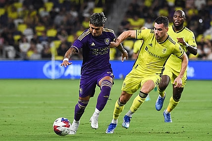 Oct 4, 2023; Nashville, Tennessee, USA; Orlando City forward Facundo Torres (17) dribbles the ball as Nashville SC defender Daniel Lovitz (2) defends during the first half at Geodis Park. Mandatory Credit: Christopher Hanewinckel-USA TODAY Sports
