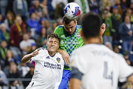 Oct 4, 2023; Seattle, Washington, USA; Seattle Sounders FC forward Jordan Morris (13, right) heads a cross against Los Angeles Galaxy defender Julian Aude (3) during the first half at Lumen Field. Mandatory Credit: Joe Nicholson-USA TODAY Sports