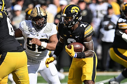 Oct 7, 2023; Iowa City, Iowa, USA; Iowa Hawkeyes running back Kaleb Johnson (2) runs the ball as Purdue Boilermakers defensive lineman Mo Omonode (92) pursues during the first quarter at Kinnick Stadium. Mandatory Credit: Jeffrey Becker-USA TODAY Sports