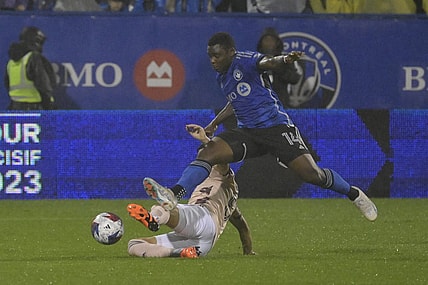 Oct 7, 2023; Montreal, Quebec, CAN; CF Montreal forward Sunusi Ibrahim (14) avoids the tackle of Portland Timbers defender Claudio Bravo (5) in the first half at Stade Saputo. Mandatory Credit: Eric Bolte-USA TODAY Sports