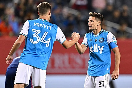 Oct 7, 2023; Chicago, Illinois, USA;  Charlotte FC midfielder Andrew Privett (34) and midfielder Ashley Westwood (8) celebrate after a victory over the Chicago Fire FC at Soldier Field. Mandatory Credit: Jamie Sabau-USA TODAY Sports