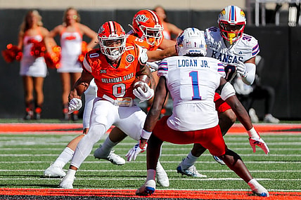 Oct 14, 2023; Stillwater, Oklahoma, USA; Oklahoma State's Ollie Gordon II (0) runs the ball against Kansas Jayhawks s Kenny Logan Jr. (1) in the first quarter at Boone Pickens Stadium. Mandatory Credit: Nathan J. Fish-USA TODAY Sports