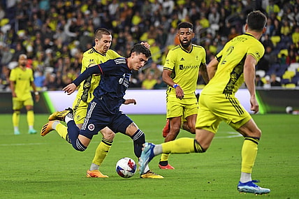 Oct 14, 2023; Nashville, Tennessee, USA; New England Revolution forward Tomas Chancalay (5) and Nashville SC midfielder Alex Muyl (19) battle for the ball during the first half at Geodis Park. Mandatory Credit: Christopher Hanewinckel-USA TODAY Sports