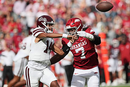 Oct 21, 2023; Fayetteville, Arkansas, USA; Mississippi State Bulldogs quarterback Mike Wright (14) throws a pass against Arkansas Razorbacks defensive lineman Trajan Jeffcoat (7) during the first quarter at Donald W. Reynolds Razorback Stadium. Mandatory Credit: Nelson Chenault-USA TODAY Sports