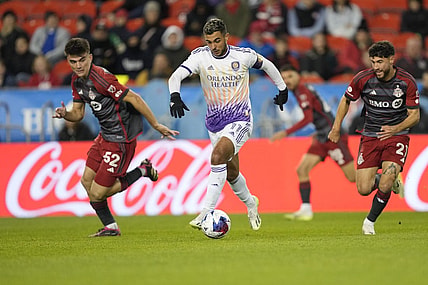 Oct 21, 2023; Toronto, Ontario, CAN; Orlando City SC midfielder Mart n Ojeda (11) dribbles the ball downfield as Toronto FC midfielder Alonso Coello (52)  and midfielder Jonathan Osorio (21)  pursue during the first half at BMO Field. Mandatory Credit: John E. Sokolowski-USA TODAY Sports