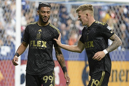 Oct 21, 2023; Vancouver, British Columbia, CAN;  Los Angeles FC midfielder Mateusz Bousz (19) reacts with forward Denis Bouanga (99) during the second half against the Vancouver Whitecaps FC at BC Place. Mandatory Credit: Anne-Marie Sorvin-USA TODAY Sports