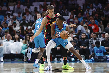 Oct 25, 2023; Charlotte, North Carolina, USA; Charlotte Hornets forward Brandon Miller (24) looks to pass around Atlanta Hawks guard Bogdan Bogdanovic (13) during the first quarter at Spectrum Center. Mandatory Credit: Nell Redmond-USA TODAY Sports