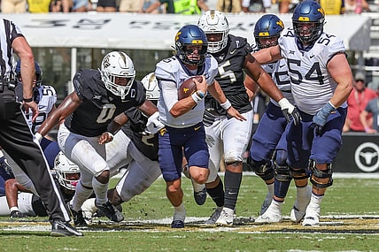 Oct 28, 2023; Orlando, Florida, USA; West Virginia Mountaineers quarterback Garrett Greene (6) carries the ball during the second quarter against the UCF Knights at FBC Mortgage Stadium. Mandatory Credit: Mike Watters-USA TODAY Sports