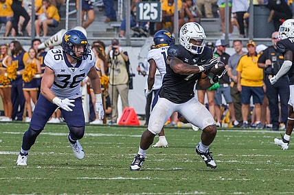 Oct 28, 2023; Orlando, Florida, USA; UCF Knights running back RJ Harvey (7) catches a pass in front of West Virginia Mountaineers linebacker Caden Biser (36) during the second half at FBC Mortgage Stadium. Mandatory Credit: Mike Watters-USA TODAY Sports