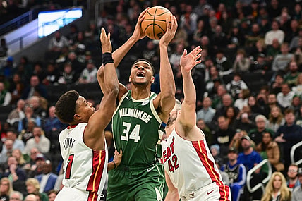 Oct 30, 2023; Milwaukee, Wisconsin, USA;  Milwaukee Bucks forward Giannis Antetokounmpo (34) takes a shot between Miami Heat guard Kyle Lowry (7) and forward Kevin Love (42) in the first quarter at Fiserv Forum. Mandatory Credit: Benny Sieu-USA TODAY Sports
