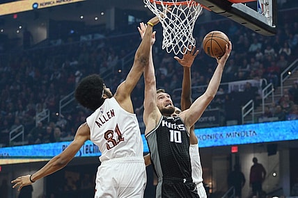 Dec 9, 2022; Cleveland, Ohio, USA; Sacramento Kings forward Domantas Sabonis (10) drives to the basket against Cleveland Cavaliers center Jarrett Allen (31) and forward Evan Mobley (4) during the first half at Rocket Mortgage FieldHouse. Mandatory Credit: Ken Blaze-USA TODAY Sports