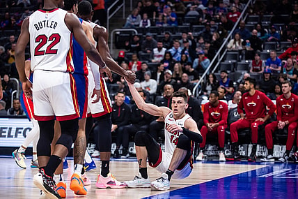 Mar 19, 2023; Detroit, Michigan, USA; Miami Heat guard Tyler Herro (14) is helped to his feet by center Bam Adebayo (13) in the first quarter against the Detroit Pistons at Little Caesars Arena. Mandatory Credit: Allison Farrand-USA TODAY Sports