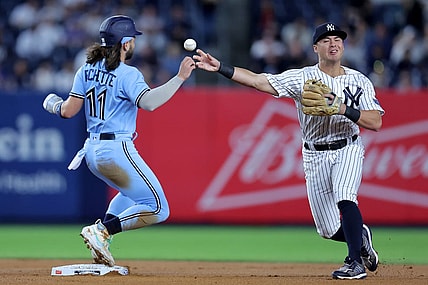 Sep 19, 2023; Bronx, New York, USA; New York Yankees shortstop Anthony Volpe (11) forces Toronto Blue Jays shortstop Bo Bichette (11) out at second and throws to first to complete a double play on a ball hit by designated hitter Vladimir Guerrero Jr. (not pictured) during the first inning at Yankee Stadium. Mandatory Credit: Brad Penner-USA TODAY Sports
