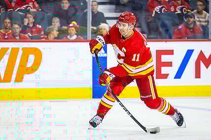 Oct 24, 2023; Calgary, Alberta, CAN; Calgary Flames center Mikael Backlund (11) shoot the puck against the New York Rangers during the second period at Scotiabank Saddledome. Mandatory Credit: Sergei Belski-USA TODAY Sports