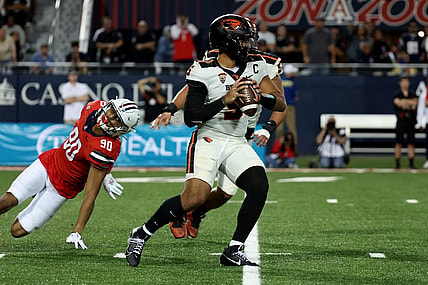 Oct 28, 2023; Tucson, Arizona, USA; Oregon State Beavers quarterback DJ Uiagalelei #5 makes a pass against Arizona Wildcats defensive lineman Isaiah Ward #90 during the second half at Arizona Stadium. Mandatory Credit: Zachary BonDurant-USA TODAY Sports