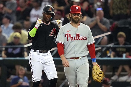 Arizona Diamondbacks shortstop Geraldo Perdomo (left) reacts after hitting a single during the seventh inning as Philadelphia Phillies first baseman Bryce Harper (right) looks on in game four of the NLCS of the 2023 MLB playoffs at Chase Field in Phoenix on Oct. 20, 2023.