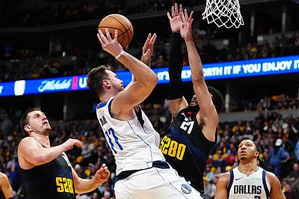 Nov 3, 2023; Denver, Colorado, USA; Dallas Mavericks guard Luka Doncic (77) shoots the ball at Denver Nuggets center Nikola Jokic (15) and guard Jamal Murray (27) in the second half at Ball Arena. Mandatory Credit: Ron Chenoy-USA TODAY Sports