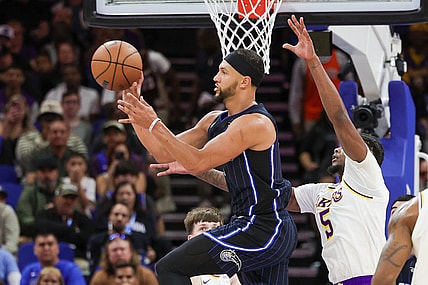 Nov 4, 2023; Orlando, Florida, USA; Orlando Magic guard Jalen Suggs (4) passes the ball in front of Los Angeles Lakers forward Cam Reddish (5) during the first quarter at Amway Center. Mandatory Credit: Mike Watters-USA TODAY Sports