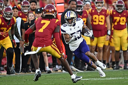 Nov 4, 2023; Los Angeles, California, USA; Washington Huskies running back Tybo Rogers (20) carries the ball against USC Trojans safety Calen Bullock (7) during the second quarter at United Airlines Field at Los Angeles Memorial Coliseum. Mandatory Credit: Jonathan Hui-USA TODAY Sports