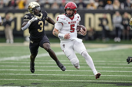 Nov 11, 2023; Winston-Salem, North Carolina, USA;  North Carolina State Wolfpack quarterback Brennan Armstrong (5) tries to outrun Wake Forest Demon Deacons defensive back Malik Mustapha (3) during the first half at Allegacy Federal Credit Union Stadium. Mandatory Credit: Jim Dedmon-USA TODAY Sports